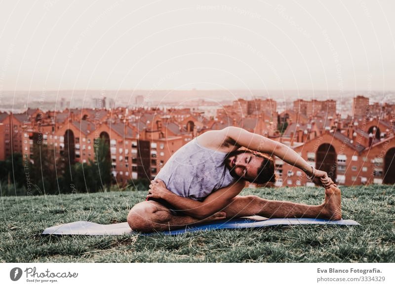 junger Mann in einem Park, der Yoga-Sport betreibt. Stadthintergrund. gesunde Lebensweise. Jugendliche Großstadt Sonnenuntergang Lifestyle Gesundheit Unterlage