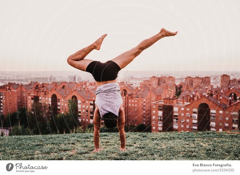 junger Mann in einem Park, der Yoga-Sport betreibt. Stadthintergrund. gesunde Lebensweise. Jugendliche Großstadt Sonnenuntergang Lifestyle Gesundheit Unterlage