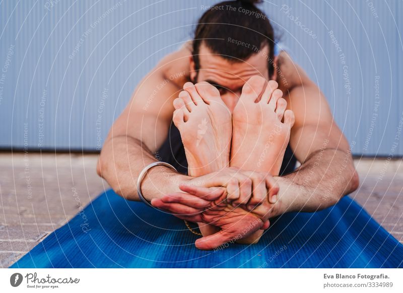 mann in der stadt, der yoga-sport betreibt. blauer hintergrund. gesunde lebensweise Yoga Mann Sport Gesundheit Außenaufnahme Großstadt Blauer Hintergrund