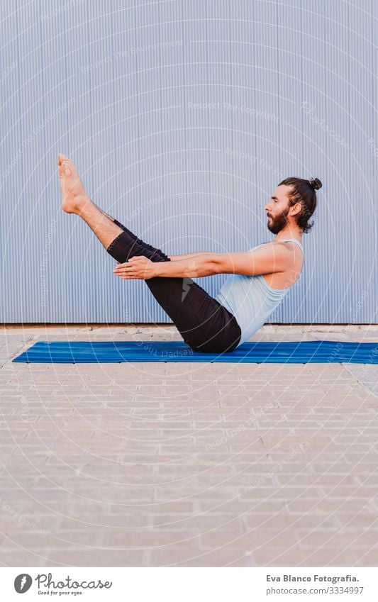 mann in der stadt, der yoga-sport betreibt. blauer hintergrund. gesunde lebensweise Yoga Mann Sport Gesundheit Außenaufnahme Großstadt Blauer Hintergrund