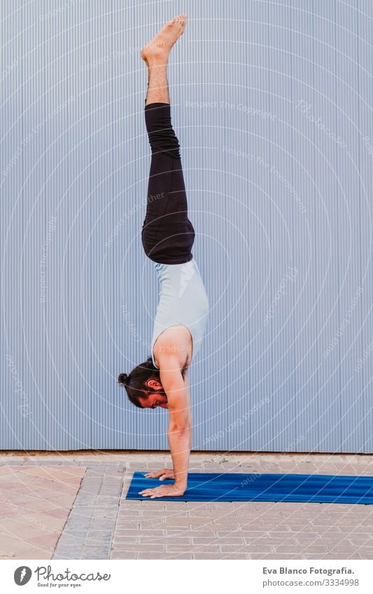 mann in der stadt, der yoga-sport betreibt. blauer hintergrund. gesunde lebensweise Yoga Mann Sport Gesundheit Außenaufnahme Großstadt Blauer Hintergrund