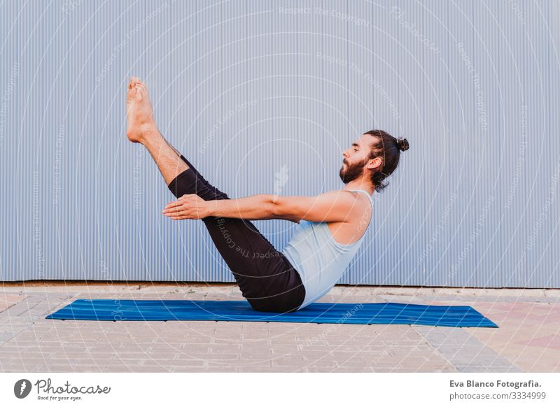 mann in der stadt, der yoga-sport betreibt. blauer hintergrund. gesunde lebensweise Yoga Mann Sport Gesundheit Außenaufnahme Großstadt Blauer Hintergrund