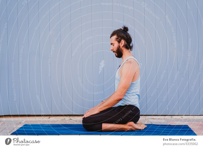 mann in der stadt, der yoga-sport betreibt. blauer hintergrund. gesunde lebensweise Yoga Mann Sport Gesundheit Außenaufnahme Großstadt Blauer Hintergrund