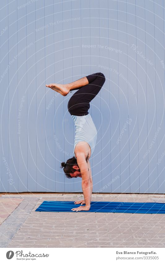 mann in der stadt, der yoga-sport betreibt. blauer hintergrund. gesunde lebensweise Yoga Mann Sport Gesundheit Außenaufnahme Großstadt Blauer Hintergrund