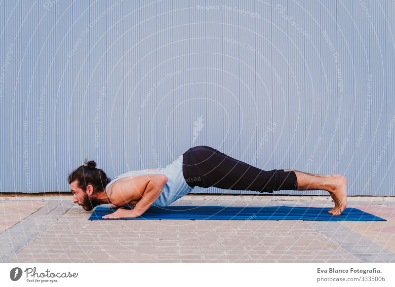 mann in der stadt, der yoga-sport betreibt. blauer hintergrund. gesunde lebensweise Yoga Mann Sport Gesundheit Außenaufnahme Großstadt Blauer Hintergrund