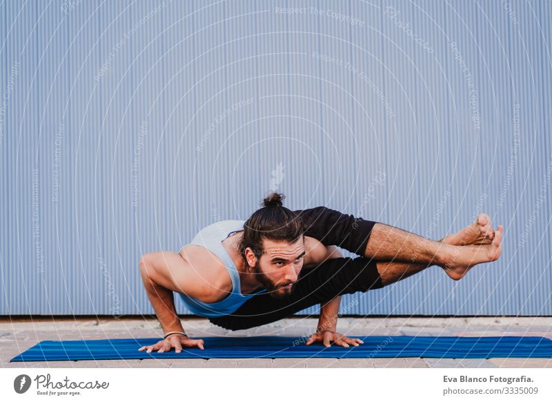 mann in der stadt, der yoga-sport betreibt. blauer hintergrund. gesunde lebensweise Yoga Mann Sport Gesundheit Außenaufnahme Großstadt Blauer Hintergrund