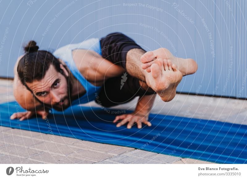 mann in der stadt, der yoga-sport betreibt. blauer hintergrund. gesunde lebensweise Yoga Mann Sport Gesundheit Außenaufnahme Großstadt Blauer Hintergrund