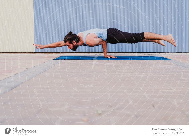 mann in der stadt, der yoga-sport betreibt. blauer hintergrund. gesunde lebensweise Yoga Mann Sport Gesundheit Außenaufnahme Großstadt Blauer Hintergrund