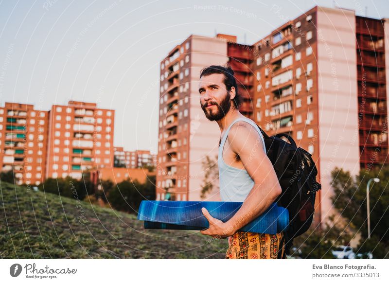 junger Mann in einem Park, der bereit ist, Yogasport zu betreiben. Jugendliche Sport Großstadt Sonnenuntergang Lifestyle Gesundheit Unterlage Sportkleidung