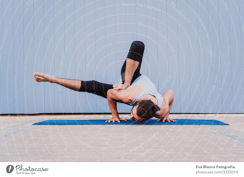 mann in der stadt, der yoga-sport betreibt. blauer hintergrund. gesunde lebensweise Yoga Mann Sport Gesundheit Außenaufnahme Großstadt Blauer Hintergrund