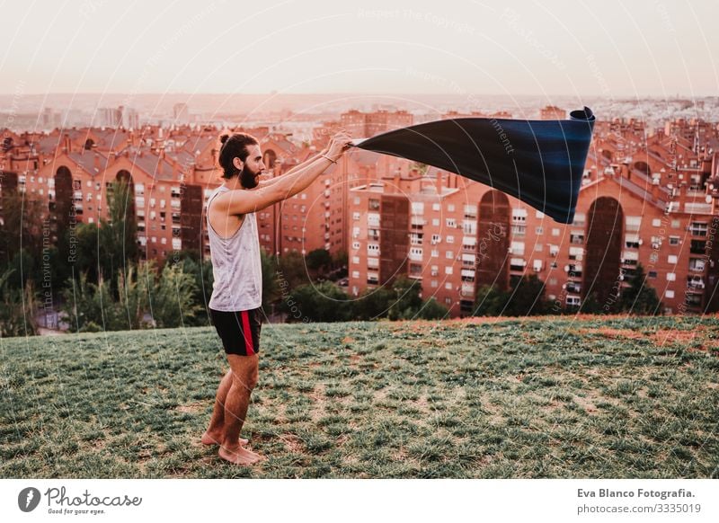 junger Mann in einem Park, der bereit ist, Yogasport zu betreiben. Jugendliche Sport Großstadt Sonnenuntergang Lifestyle Gesundheit Unterlage Sportkleidung