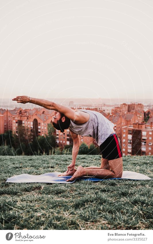 junger Mann in einem Park, der Yoga-Sport betreibt. Stadthintergrund. gesunde Lebensweise. Jugendliche Großstadt Sonnenuntergang Lifestyle Gesundheit Unterlage