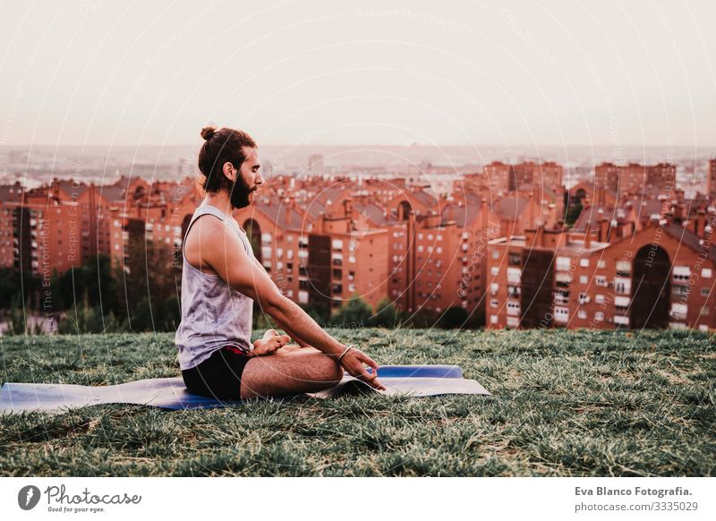 junger Mann in einem Park, der Yoga-Sport betreibt. Stadthintergrund. gesunde Lebensweise. Jugendliche Großstadt Sonnenuntergang Lifestyle Gesundheit Unterlage