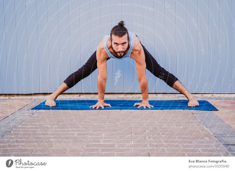 mann in der stadt, der yoga-sport betreibt. blauer hintergrund. gesunde lebensweise Yoga Mann Sport Gesundheit Außenaufnahme Großstadt Blauer Hintergrund