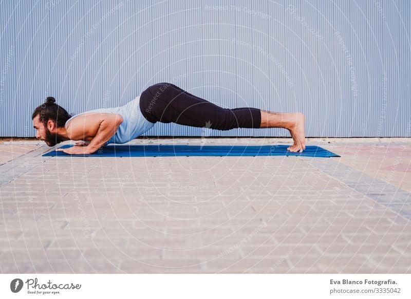 mann in der stadt, der yoga-sport betreibt. blauer hintergrund. gesunde lebensweise Yoga Mann Sport Gesundheit Außenaufnahme Großstadt Blauer Hintergrund