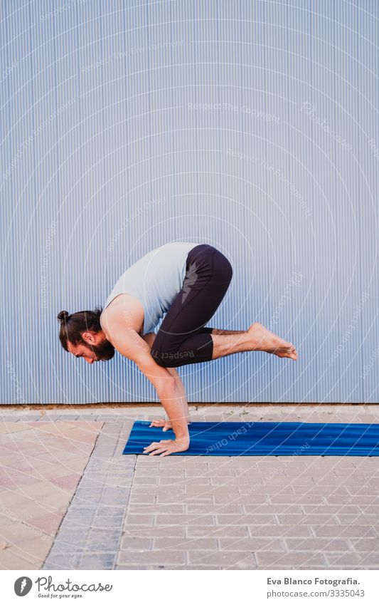 mann in der stadt, der yoga-sport betreibt. blauer hintergrund. gesunde lebensweise Yoga Mann Sport Gesundheit Außenaufnahme Großstadt Blauer Hintergrund