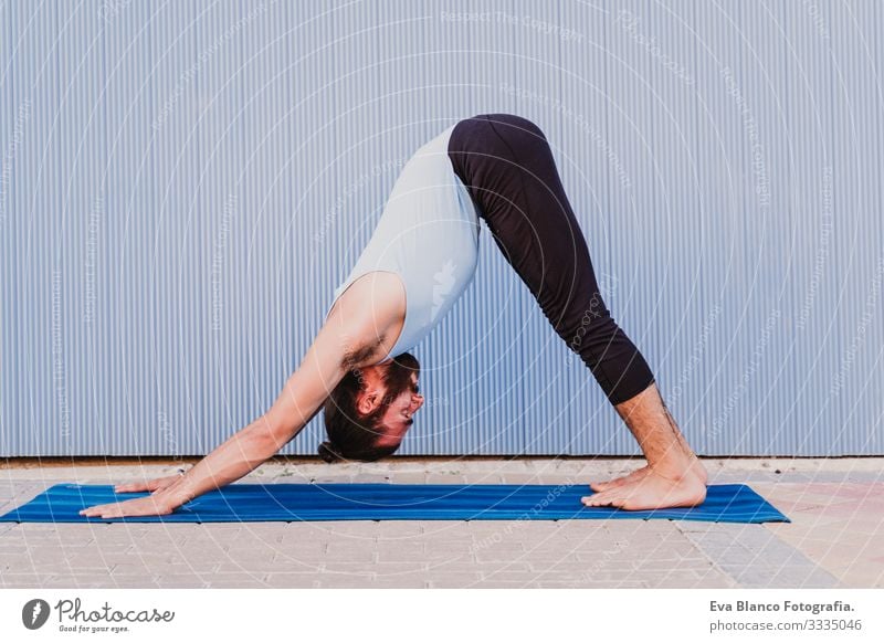 mann in der stadt, der yoga-sport betreibt. blauer hintergrund. gesunde lebensweise Yoga Mann Sport Gesundheit Außenaufnahme Großstadt Blauer Hintergrund