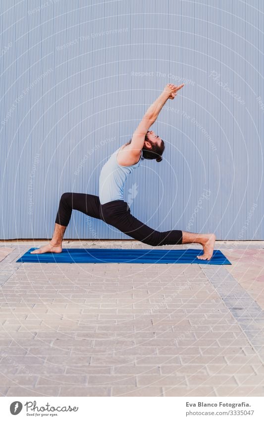 mann in der stadt, der yoga-sport betreibt. blauer hintergrund. gesunde lebensweise Yoga Mann Sport Gesundheit Außenaufnahme Großstadt Blauer Hintergrund