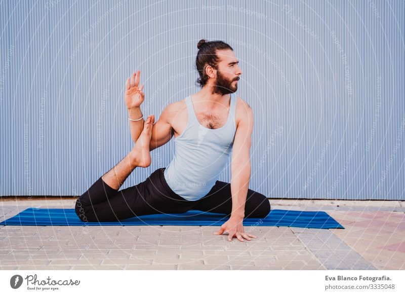 mann in der stadt, der yoga-sport betreibt. blauer hintergrund. gesunde lebensweise Yoga Mann Sport Gesundheit Außenaufnahme Großstadt Blauer Hintergrund