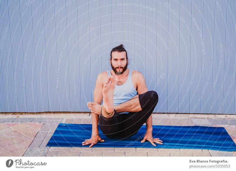 mann in der stadt, der yoga-sport betreibt. blauer hintergrund. gesunde lebensweise Yoga Mann Sport Gesundheit Außenaufnahme Großstadt Blauer Hintergrund