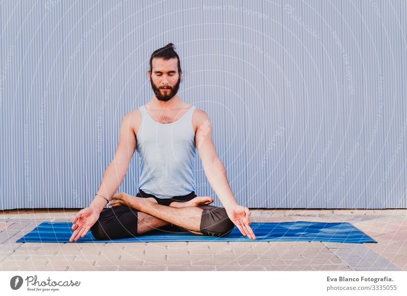 mann in der stadt, der yoga-sport betreibt. blauer hintergrund. gesunde lebensweise Yoga Mann Sport Gesundheit Außenaufnahme Großstadt Blauer Hintergrund