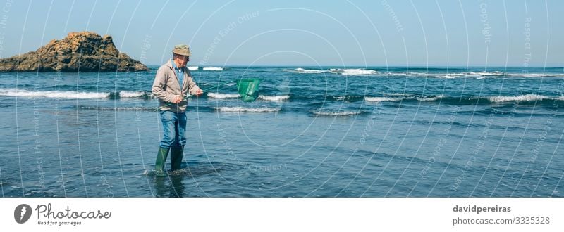 Freiwillige Helferin, die den Müll aus dem Meer holt Strand Arbeit & Erwerbstätigkeit Internet Mensch Mann Erwachsene Großvater Umwelt Natur Landschaft Felsen