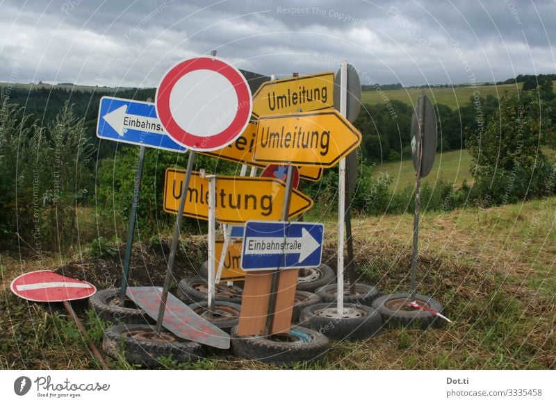 Verkehrsschilder abgestellt auf einer Wiese Natur Himmel Wolken Gras Feld Wald Hügel Verkehrszeichen Zeichen Schriftzeichen Ziffern & Zahlen