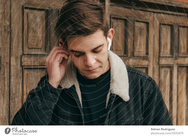 Männlicher Teenager, der mit drahtlosen Kopfhörern Musik hört Freiheit Winter Entertainment Telefon Headset Technik & Technologie Mann Erwachsene hören modern