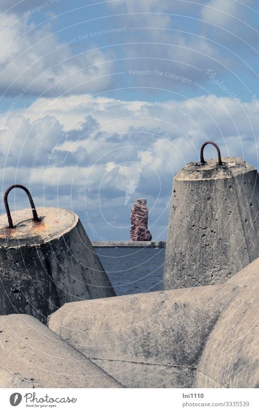 Blick durch zwei Tetrapoden übers Meer auf Lange Anna auf Helgoland vor blauem Wolkenhimmel Fortschritt Zukunft Natur Landschaft Küste Nordsee Insel grau rot