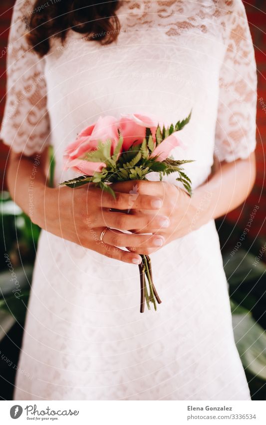 Braut hält ihren kleinen Hochzeitsstrauß aus rosa Rosen feminin Frau Erwachsene Pflanze Blumenstrauß Liebe Zusammensein Romantik Farbe Idee Ordnung Tradition