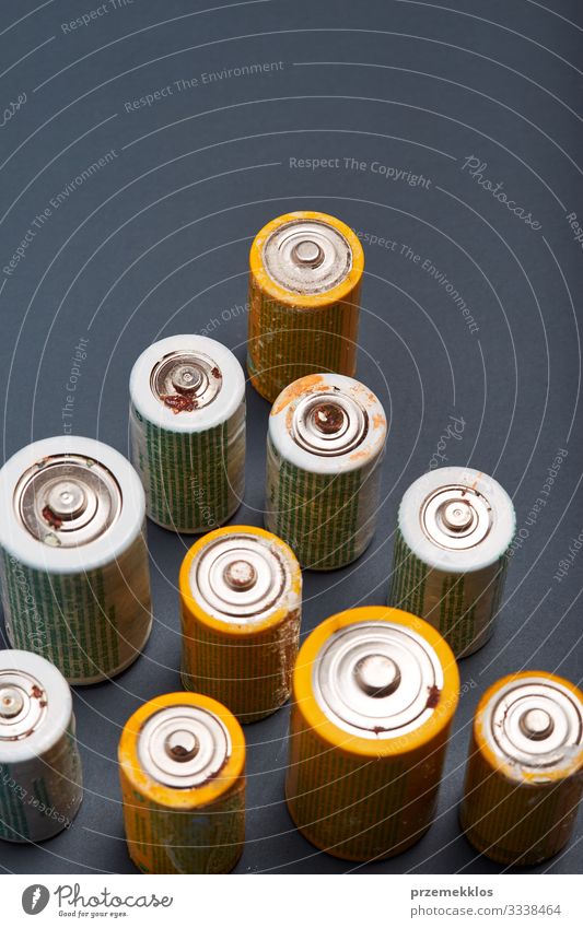 Entladene Batterien auf Papierhintergrund. Sammeln von gebrauchten Batterien zum Recycling. Abfallentsorgung und Recycling. Kopierplatz für Text Umwelt alt grün