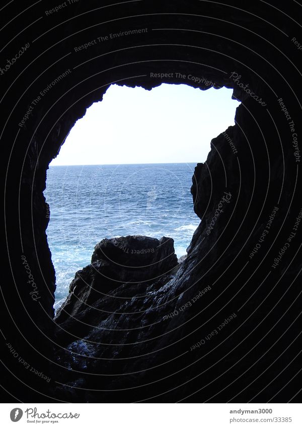 HöBlick aus Höhle Meer dunkel schwarz Licht Durchbruch hell blau Wasser