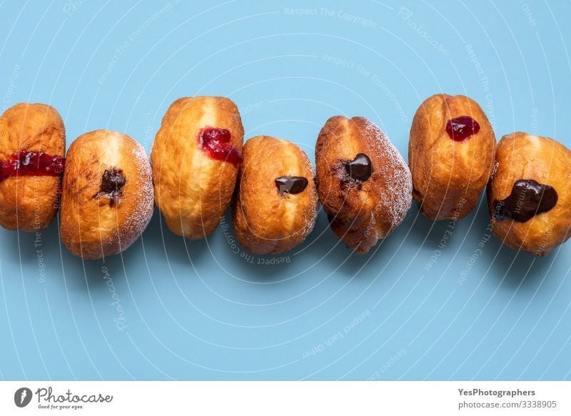 Hausgemachte Donuts in einer Reihe. Berliner Donuts mit Schokolade Kuchen Dessert Süßwaren Marmelade lecker Tradition Deutschland obere Ansicht Bäckerei