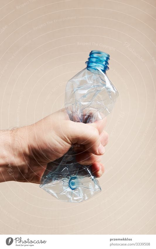 Männliche Hand hält gequetschte Plastikflasche Flasche sparen Mann Erwachsene Umwelt Container Kunststoff blau Umweltverschmutzung Müll wiederverwerten