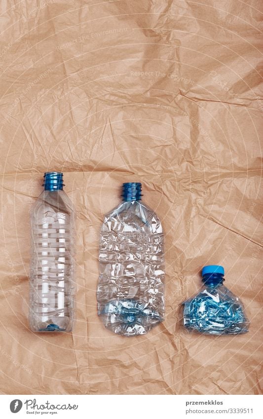 Zerquetschte leere Plastikflaschen in eine Reihe gestellt Flasche sparen Umwelt Container Papier Kunststoff blau braun Umweltverschmutzung Umweltschutz