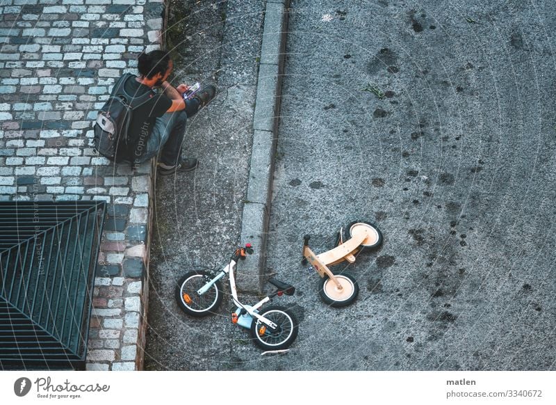 Spielstrasse maskulin 1 Mensch Stadt Verkehrswege Straße liegen sitzen blau gelb grau Kinderfahrrad Asphalt Farbfoto Gedeckte Farben Außenaufnahme