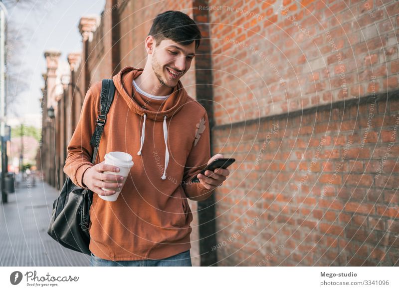 Ein Mann, der sein Handy benutzt. Lifestyle Stil Freude Glück Zufriedenheit Telefon PDA Technik & Technologie Mensch Erwachsene 1 18-30 Jahre Jugendliche Straße