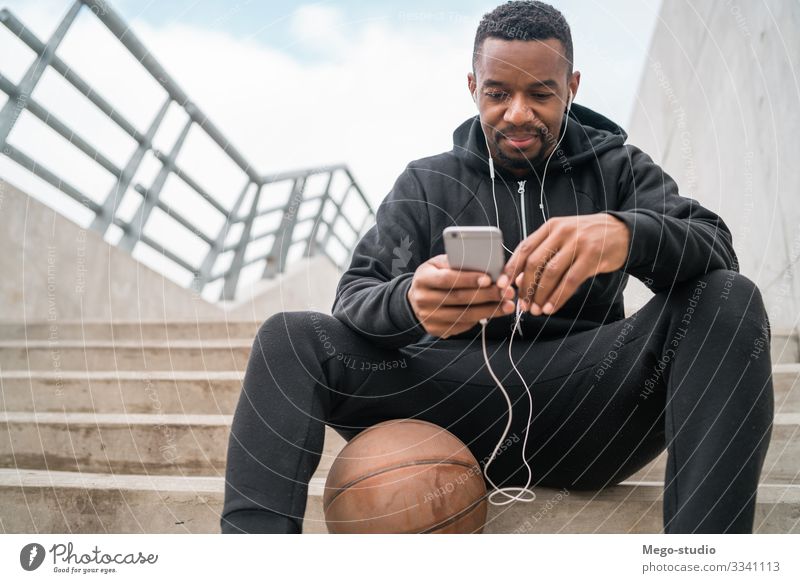 Sportler, der sein Mobiltelefon benutzt. Lifestyle Freizeit & Hobby Telefon PDA Technik & Technologie Mensch Mann Erwachsene 1 30-45 Jahre Fitness genießen