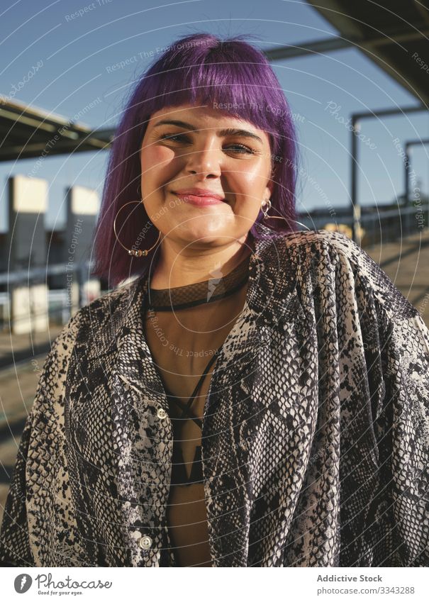 Frau mit violettem Haar schaut in die Kamera stylisch urban purpur Frisur Konstruktion glänzend Struktur Revier selbstbewusst Mode jung Stil Model Straße