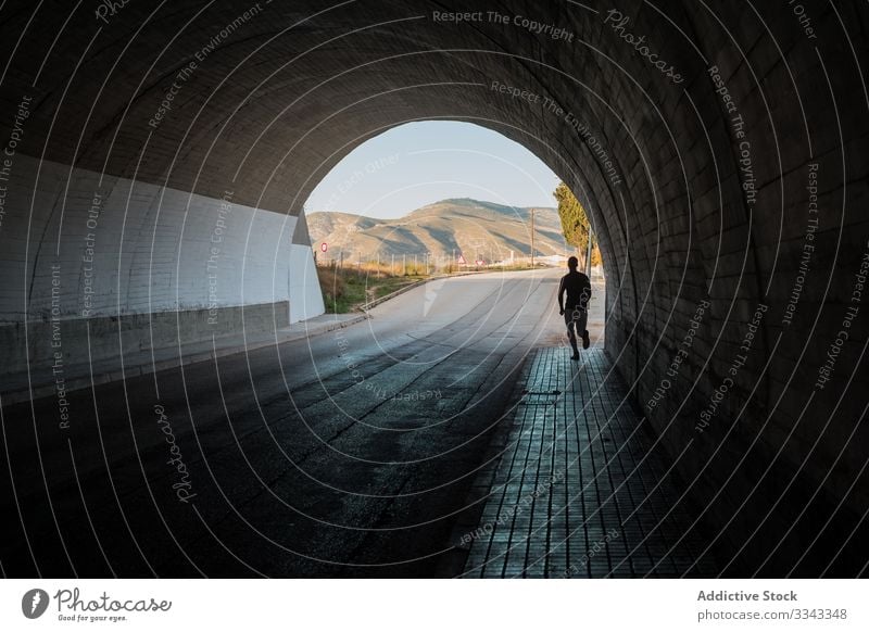 Aktiver Typ beim Joggen im Tunnel Mann joggen Stollen Training Straße Sport Gesundheit aktiv Bürgersteig Silhouette männlich urban Beine Läufer Athlet Lifestyle