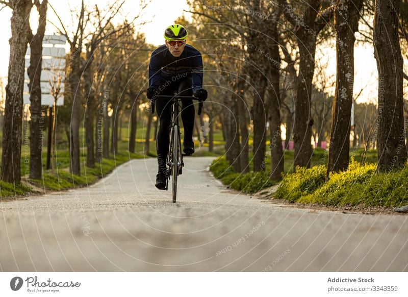 Mann radelt in einem Park Rennen Freiheit Schutzhelm Mitfahrgelegenheit Geschwindigkeit Fahrrad Zyklus Radfahrer Übung schnell Fitness Person Sport Abenteuer