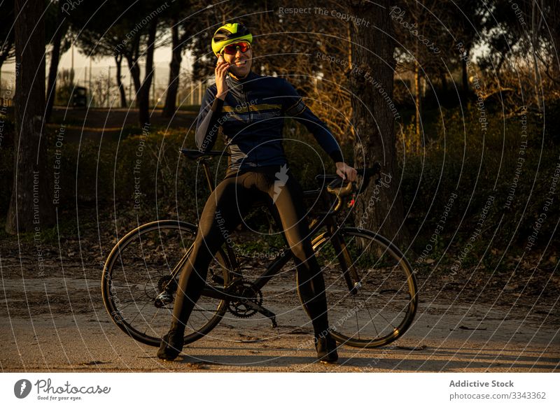 Mann fährt mit dem Handy in einem Park Rad Freiheit Schutzhelm Mitfahrgelegenheit Fahrrad Radfahrer Übung Fitness Person Sport Abenteuer Gesundheit Lifestyle