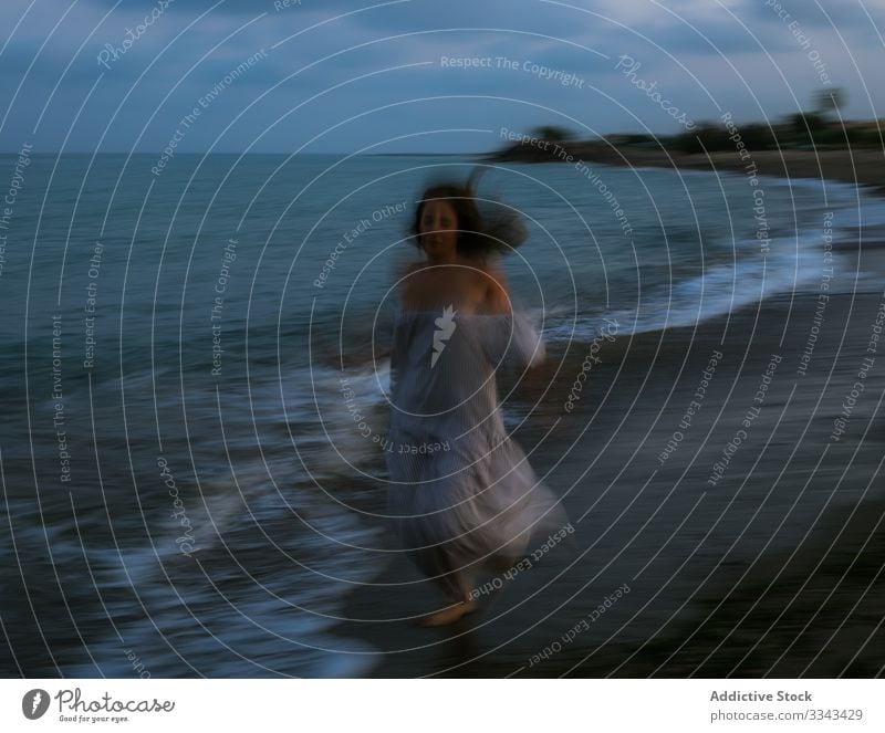 Weibliche Touristen am Meer Frau Strand Wellen Seeküste Barfuß Meeresufer Himmel Himmel (Jenseits) Abenddämmerung Wolken Dame laufen Küstenlinie leer einsam