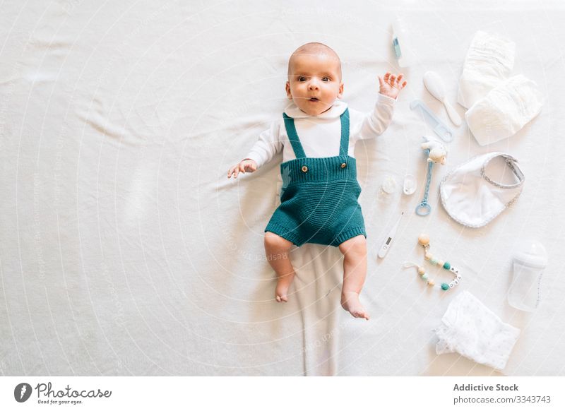 Überraschtes Baby im Bett liegend Lügen Spielzeug neugeboren heimwärts überrascht neugierig Säugling offener Mund bezaubernd Kind klein niedlich wow süß Pyjama