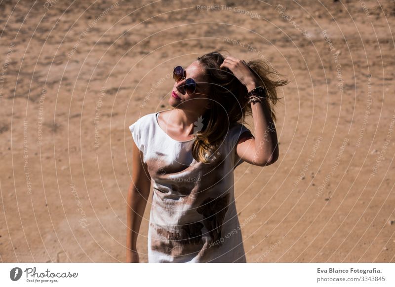 junge schöne Frau, die mit den Haaren spielt. im Freien. sonnig. Freiheit Beautyfotografie Kaukasier Blume Außenaufnahme Jugendliche Erotik Glück Gesicht