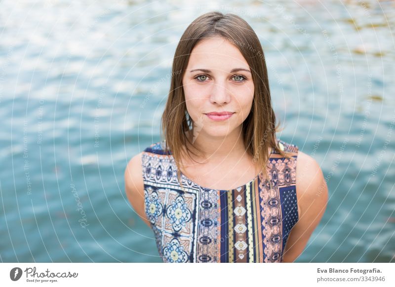 Porträt einer schönen jungen Frau im Freien, die in die Kamera schaut und lächelt. blauer Wasserhintergrund Jugendliche Glück Mädchen Lifestyle Beautyfotografie