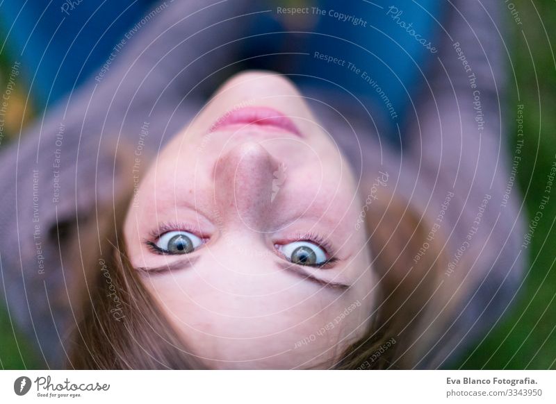 das Porträt einer schönen jungen Frau im Freien, die in die Kamera schaut und lächelt. Grüner Hintergrund Jugendliche Glück Mädchen Lifestyle Beautyfotografie