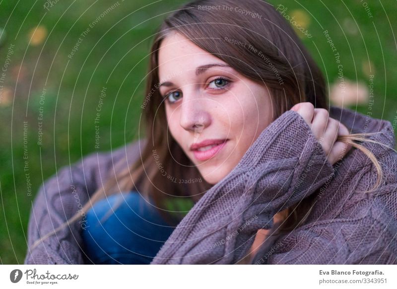 das Porträt einer schönen jungen Frau im Freien, die in die Kamera schaut und lächelt. Grüner Hintergrund Jugendliche Glück Mädchen Lifestyle Beautyfotografie