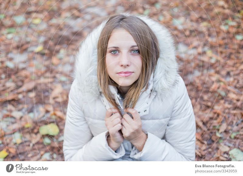 das Porträt einer schönen jungen Frau im Freien, die in die Kamera schaut und lächelt. Frau posiert im Herbst. Sonnenuntergang Jugendliche Glück Mädchen