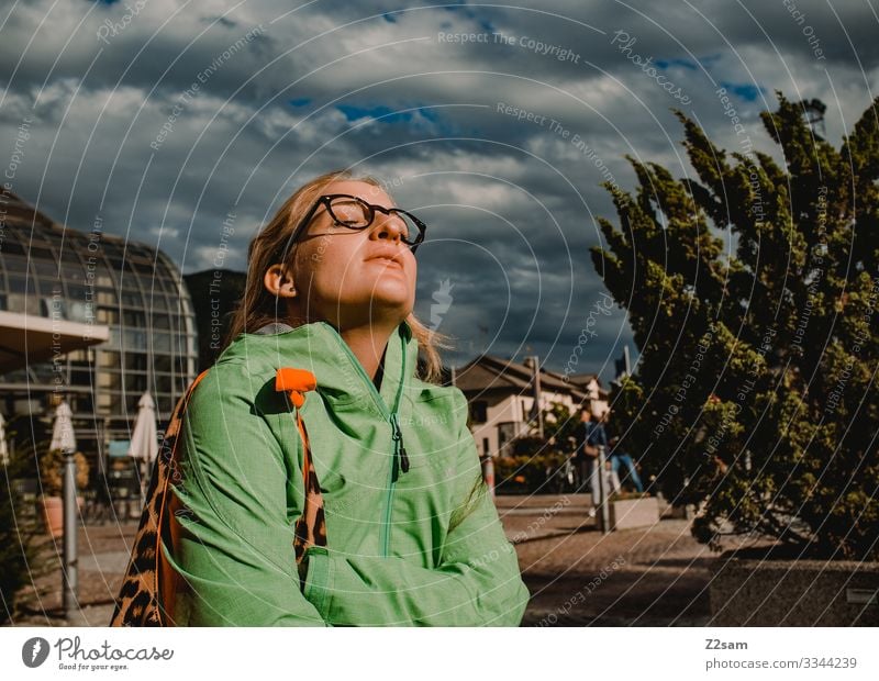 Frau genießt die Sonne stadt dorf sonne genießen frau sightseeing gewitterwolken sonnenstrahlen wärme wohlfühlen erholung urlaub ferien süden entspannen warten